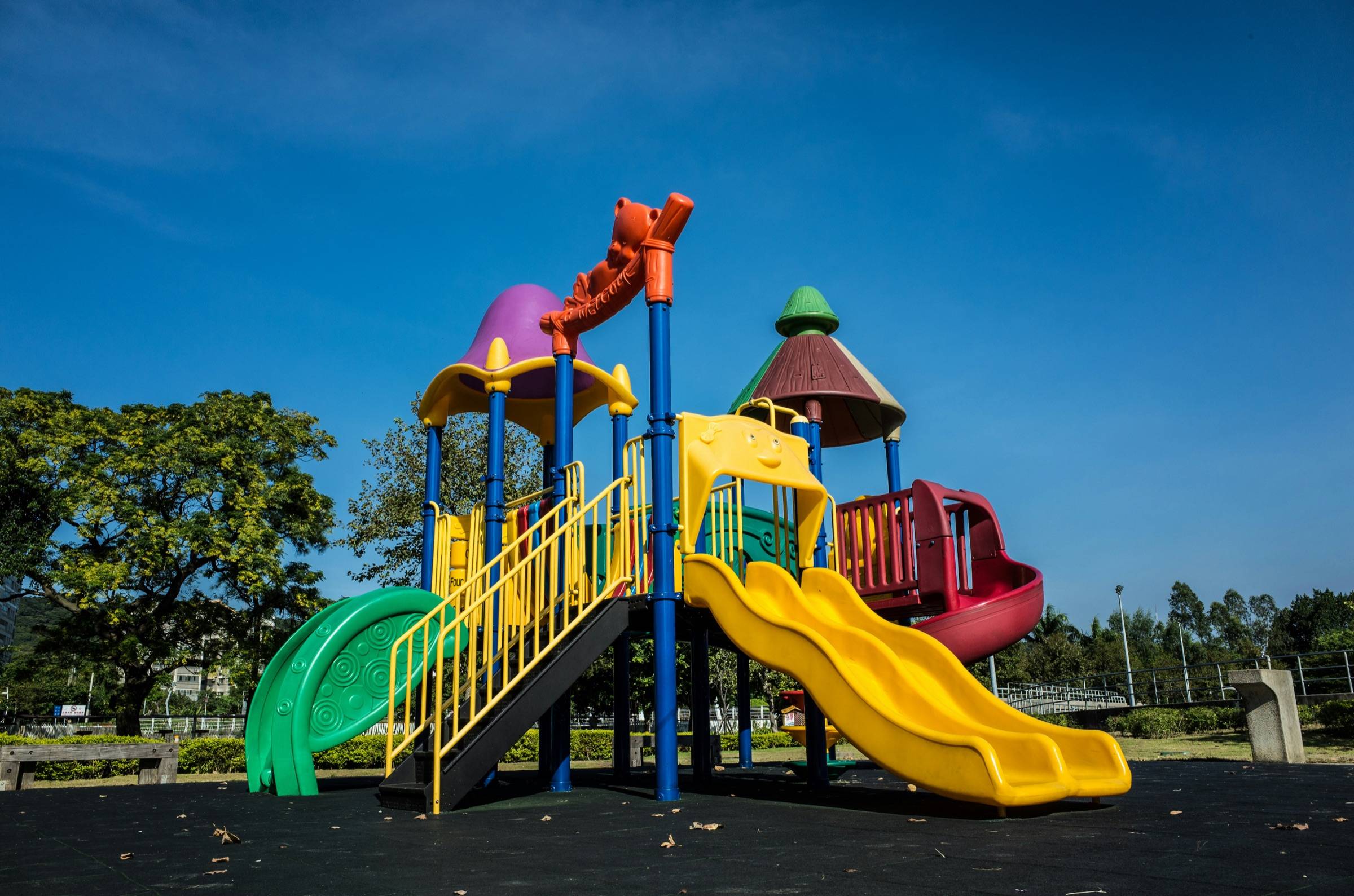 Colorful multi-deck play structure with tube and wave slides under a blue sky